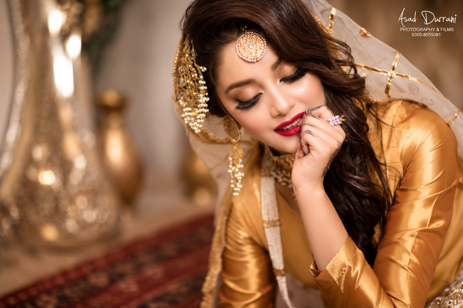 Close-up bridal portrait in gold outfit with maang tikka